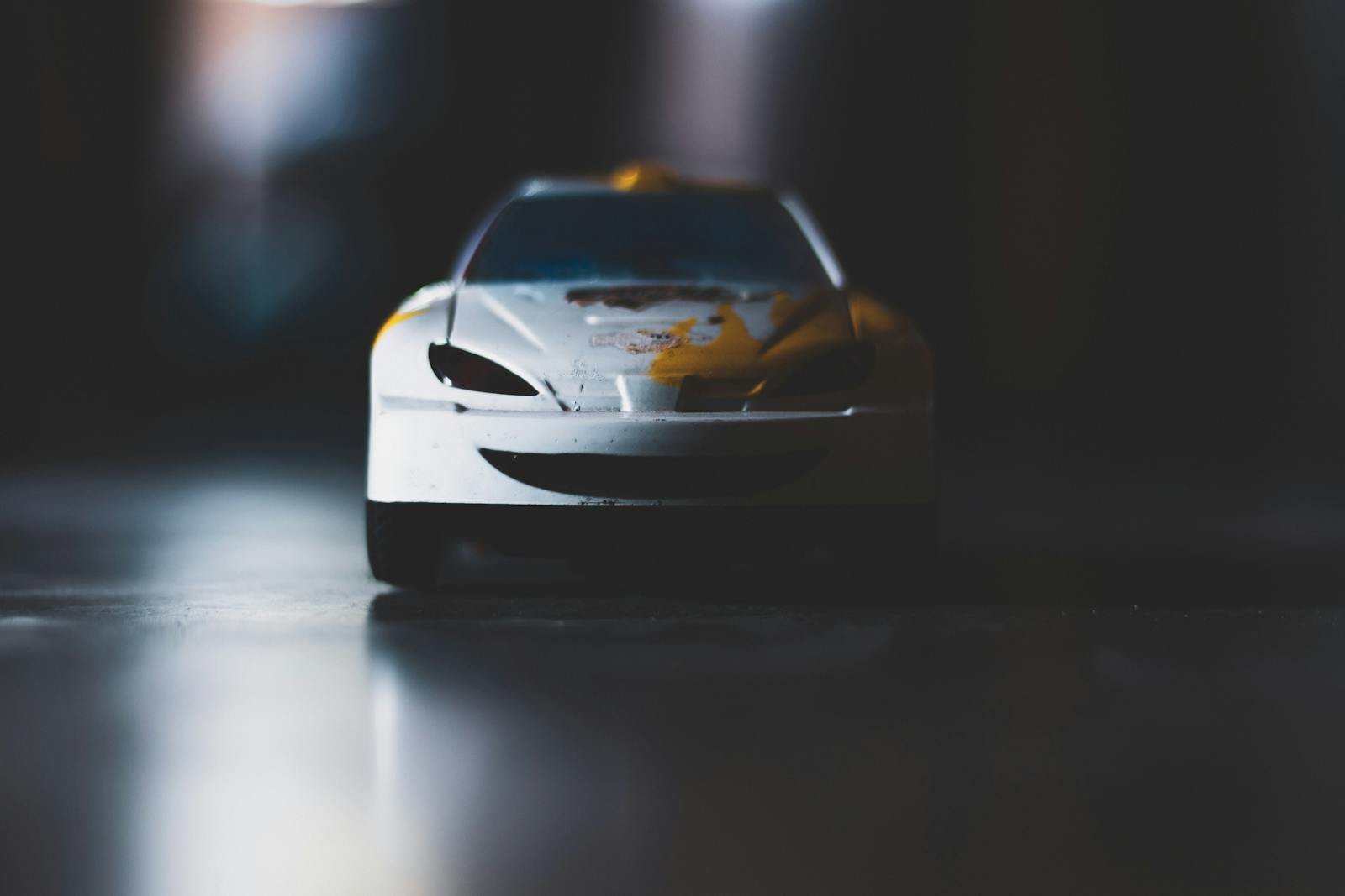 Detailed shot of a toy car with focus on the headlights and hood, showcasing depth of field.